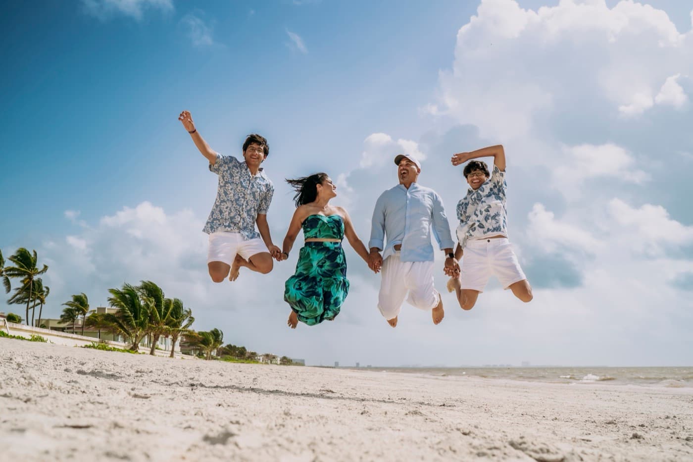 Ricardo Jiménez, su esposa Sofía y sus hijos Ricky y Christian saltando juntos en la playa