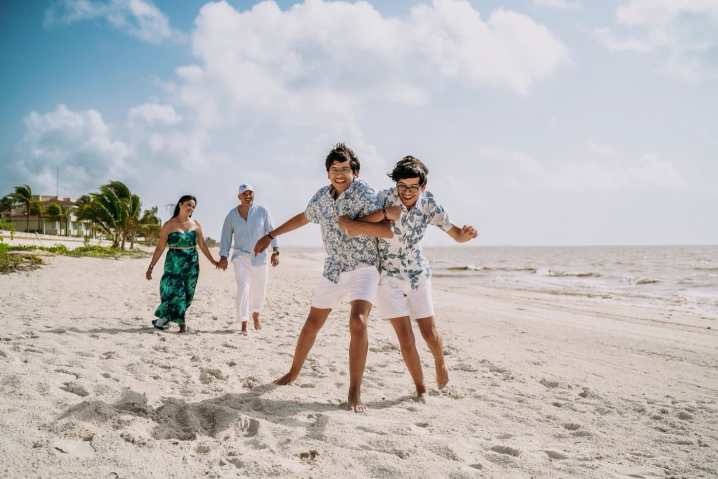 Ricky y Christian jugando mientras Ricardo y Sofía caminan detrás de ellos