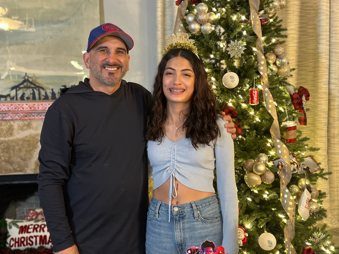 Ricardo Jiménez junto a su nieta Leah frente al árbol de Navidad